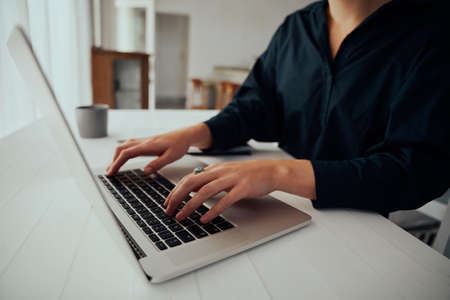 Caucasian female business woman typing on laptop working from home . High quality photoの写真素材