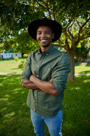 Mixed race male standing outdoors with arms crossed smiling happily. High quality photoの写真素材