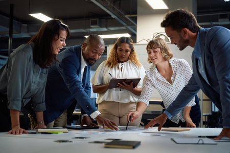 Group of multiracial business people talking and gesturing at documents during meeting in corporate...