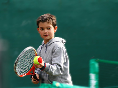 Little tennis player on a blurred green backroundの写真素材