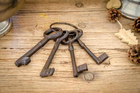 Rusty antique keys on wooden table as backgroundの写真素材