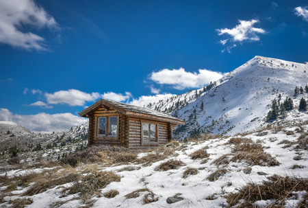 Winter snowy landscape with cabin hut amd blue sky and clouds on mountain Helmos near Kalavryta town in Greeceの写真素材