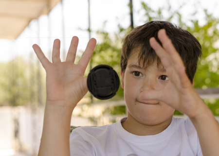 Making tricks.boy is playing with lens capの写真素材