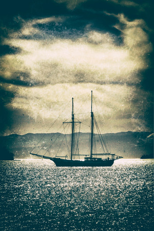 Old wooden ship in the sea under a dramatic sky.Fine art image canvas texture added.の写真素材