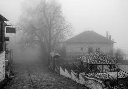 Fog and traditional stone houses in Vizitsa village on mountain Pelion. Greece.の写真素材