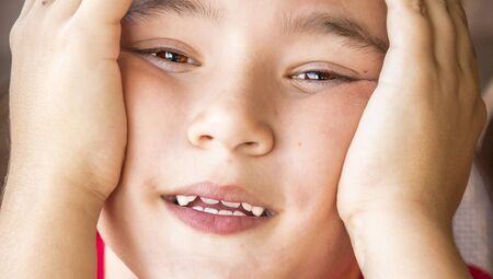 Close up portrait of a little boy with hands on your head