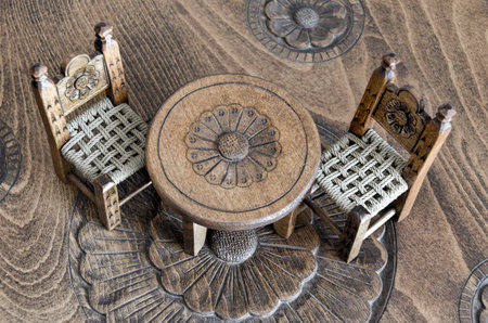 wooden miniatures hand made chairs on carved tableの写真素材