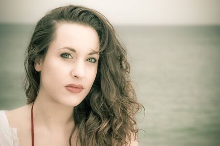 Close up portrait of a beautiful brunette woman at the beachの写真素材
