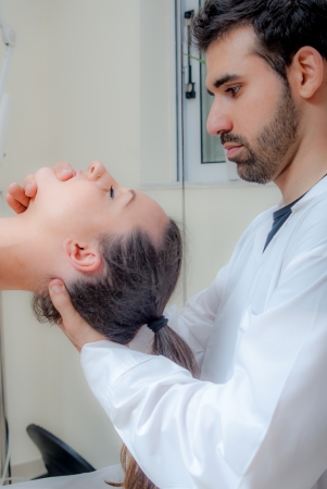 Manual, physio and kinesio therapy techniques performed by a male physiotherapist on a training plastic spine and a female patientの写真素材