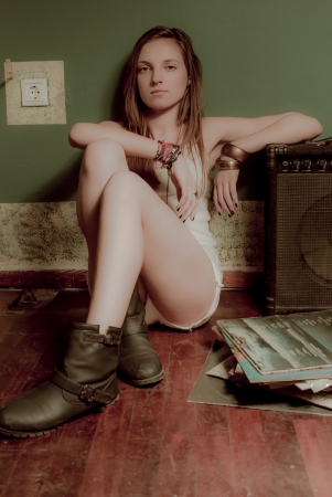 A beautifull teenage girl and a sound amplifier on an old wooden floor with fashion accessoriesの写真素材
