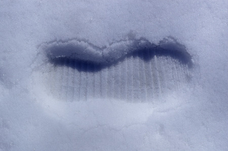 Footprint of a shoe on white snowの写真素材