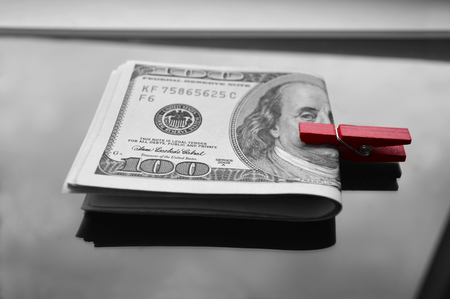 a pack of dollars clamped in a red clothespinの写真素材
