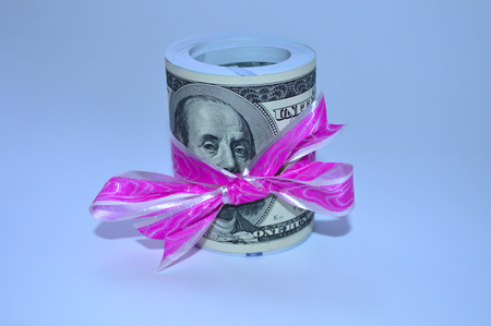A large pile of dollars tied with a pink ribbonの写真素材