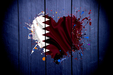 Qatar's flag in the shape of a heart on a dark backgroundの写真素材