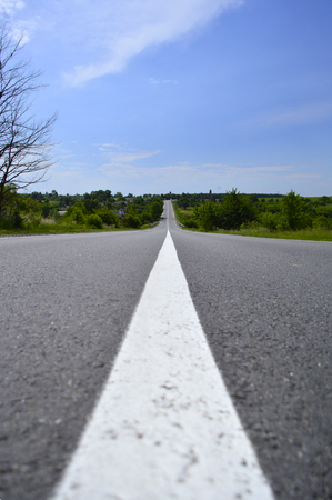 Asphalt road with markings goes into the distanceの写真素材