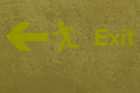EXIT sign on shabby beige wall close up