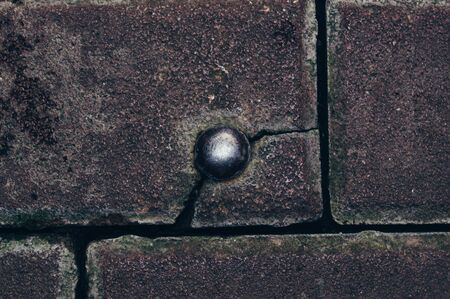 Old rivet in a cracked concrete wall.の写真素材