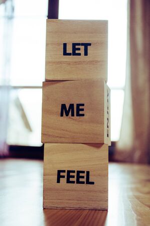 Wooden cubes with the words LET ME FEEL close upの写真素材