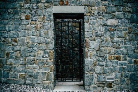 Iron door in a rough stone wall in detailの写真素材
