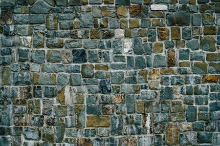 Wall of textured stones in dark colors close upの写真素材