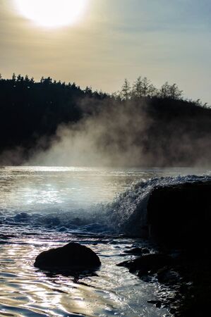 A stream of water pours into the river close up