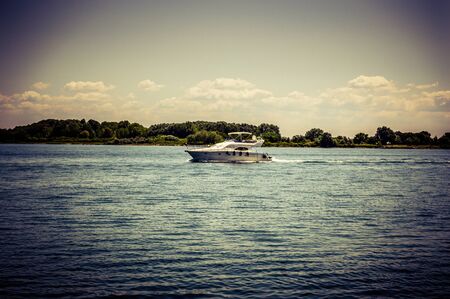 A motor boat floats on the sea against a blue sky close upの写真素材