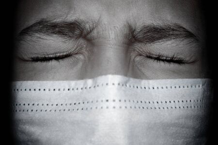 Upset teenager girl in medical mask with eyes closed close upの写真素材