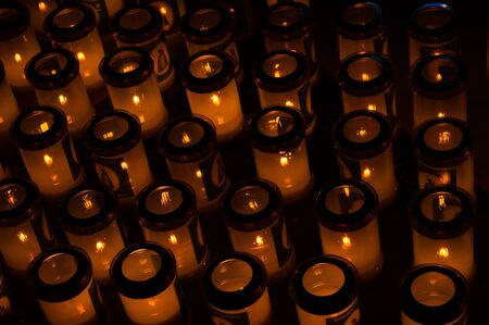 Many cups with burning candles in the church close upの写真素材