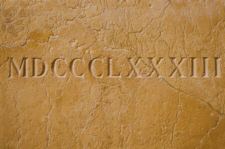 Old roman numerals engraved on a texture stone close upの写真素材