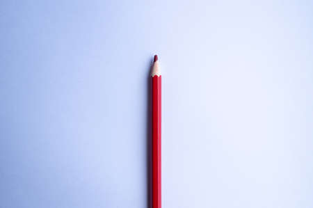Red pencil lies on a blank sheet of white paper close upの写真素材
