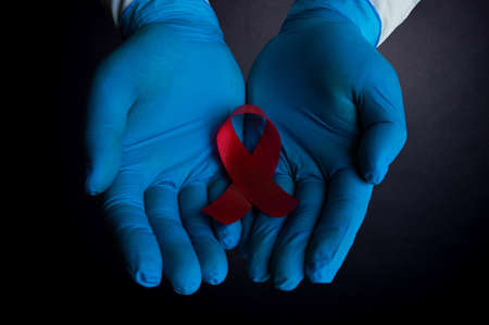 A medical worker is holding a sign of the fight against AIDS close upの写真素材