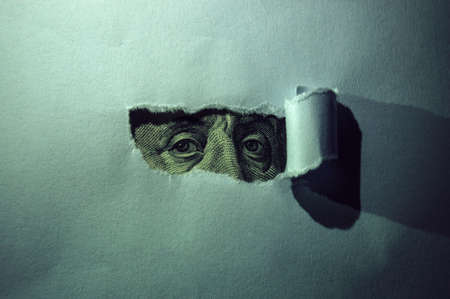 Close-up of President Franklin's eyes in a paper hole in detail