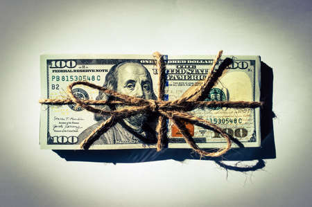 A bundle of $ 100 bills tied with twine close upの写真素材