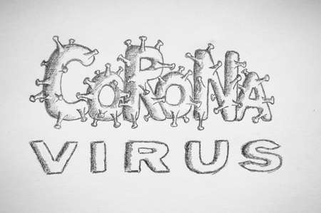 The words Corona virus are written in pencil on white paper close upの写真素材