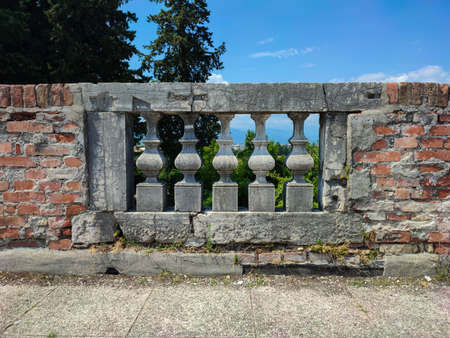 Old cracked stone balusters on the railing in detail.