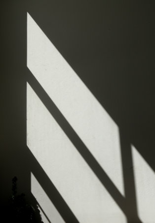 shadow on the wall of a room with a light from the window