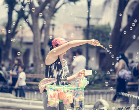 View on Girl making soap bubbles on market in Guatemala
