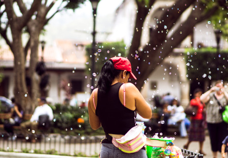 View on Girl making soap bubbles on market in Guatemala