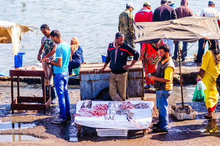 Essaouira, Morocco - November 05, 2015: View on group of Fishermen selling fresh fish on the market in the old port of the townのeditorial素材
