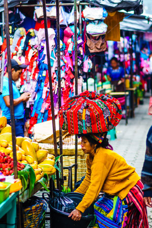 Chichicastenango, Guatemala on 2th May 2016 - View of Indingenous maya woman carry products on the top of her head on local maya marketのeditorial素材