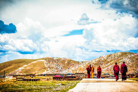 Tagong, China on 12th May 2015 - View on group of tibetan monks walking in mountain landscapeのeditorial素材