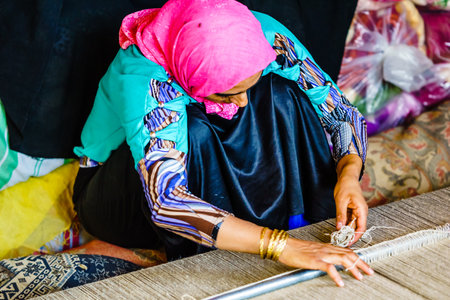 Shiraz, Iran on October 25th 2016, View on woman weaving carpetのeditorial素材