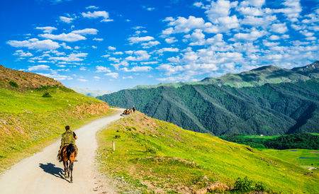 View on persons doing horse trekking in the mountains of Tusheti, Georgiaの写真素材
