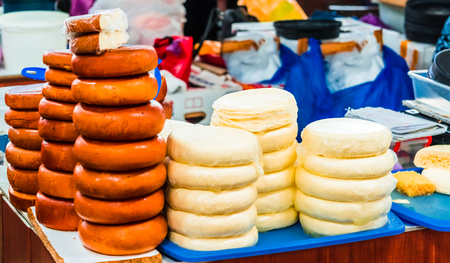 Closeup of piles of round homemade traditional cheese in the market in Georgiaの写真素材