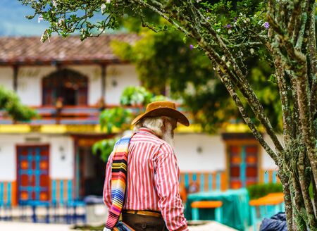 View on man wearing a sombrero and folded poncho over the shoulder in colonial village of Jardin, Colombiaの写真素材