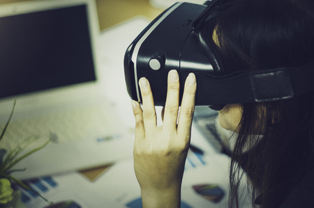 Business Woman using a VR headset for work with virtual reality, with fun and happy new experience, Concept of modern technologies and use of high-tech devices For quick communication.の写真素材