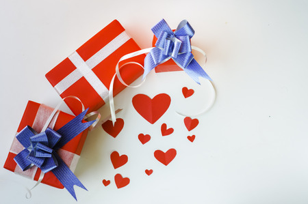 Top view Valentine day set of gift red boxes,with blue bow and ribbon, with paper heart shape,on white background,concept Celebrating festival symbolizes day of love,with copy space for text input.の写真素材