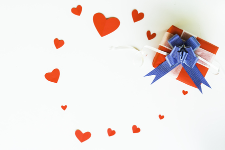 Top view Valentine day of gift red box,with blue bow and ribbon, with paper heart shape,on white background,concept Celebrating festival symbolizes day of love,with copy space for text input.の写真素材