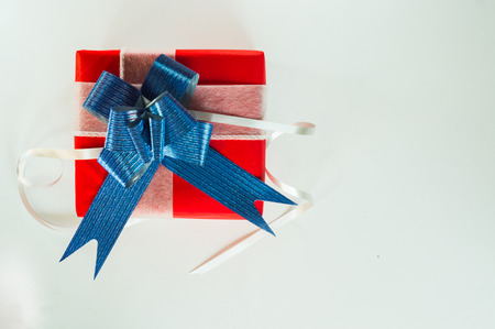 Top view Valentine day of gift red box,with blue bow and ribbon, with paper heart shape,on white isolated background,concept Celebrating festival symbolizes day of love,with copy space for text input.の写真素材
