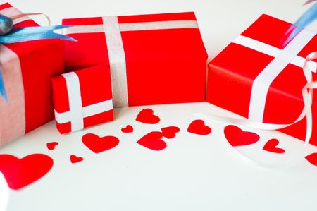 Valentine day set of gift red boxes, with blue bow and ribbon, with paper heart shape, on white background, concept Celebrating festival that symbolizes day of love.の写真素材
